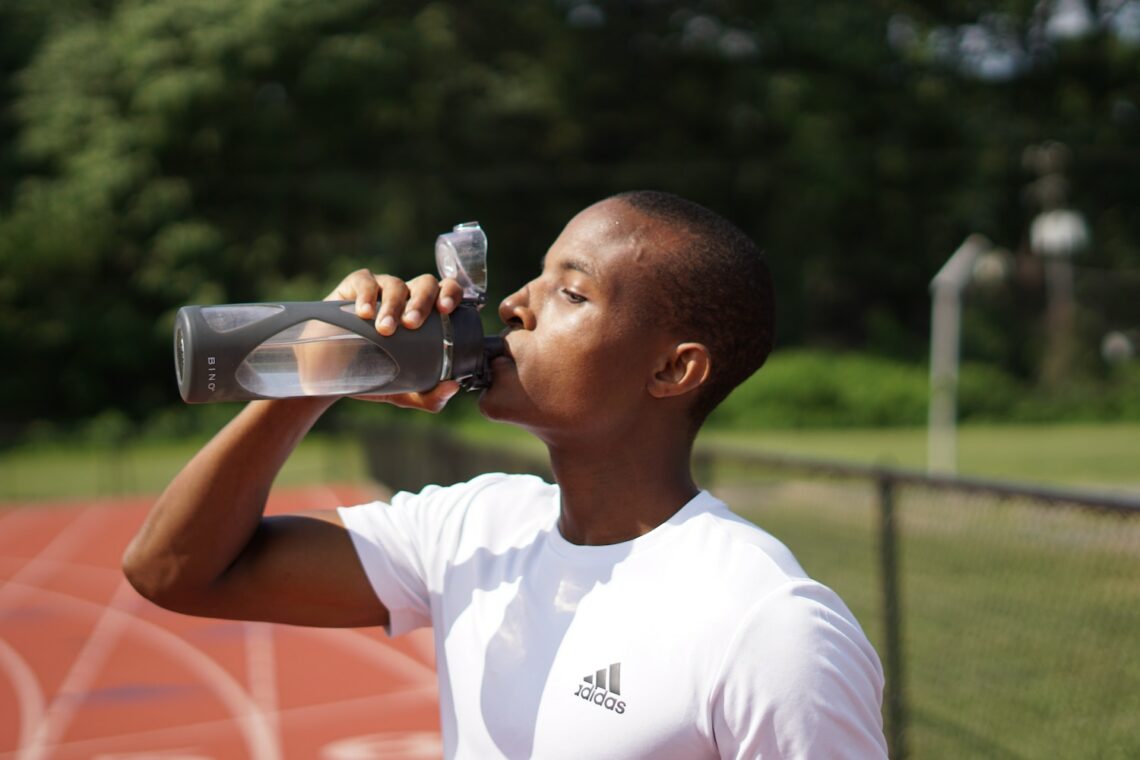 Man drinking water on a track.