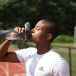 Man drinking water on a track.