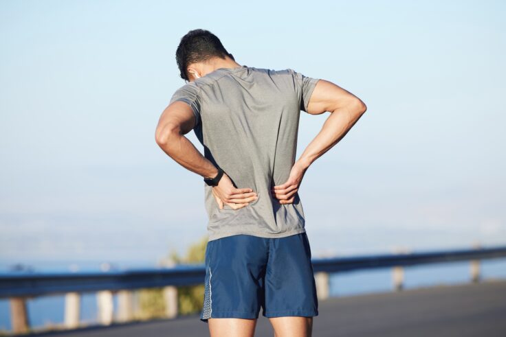 Tired man with back pain post workout.